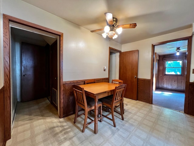 290 5th Ave, Granite Falls, MN 56241 - dining space featuring a wainscoted wall, light flooring, wood walls, and ceiling fan