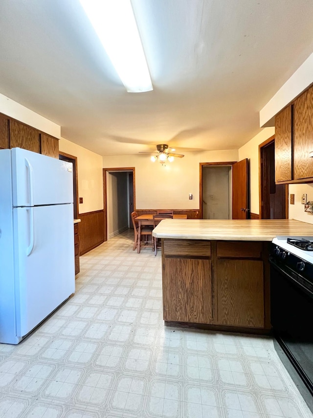 290 5th Ave, Granite Falls, MN 56241 - kitchen featuring freestanding refrigerator, range, a peninsula, light floors, and light countertops