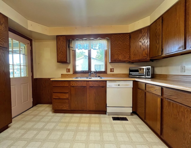 290 5th Ave, Granite Falls, MN 56241 - kitchen featuring dishwasher, wainscoting, stainless steel microwave, light countertops, and light flooring