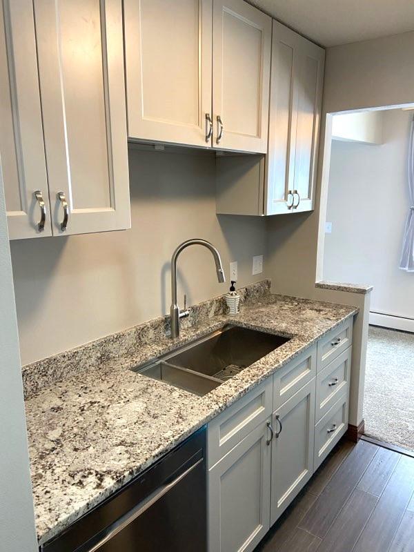4363 Wilshire Blvd Unit 302, Mound, MN 55364 - kitchen featuring dishwasher, dark wood-style flooring, light stone counters, and baseboard heating