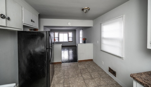 1194 Forest St, Saint Paul, MN 55106 - kitchen featuring freestanding refrigerator, white cabinetry, dark countertops, and stone finish flooring