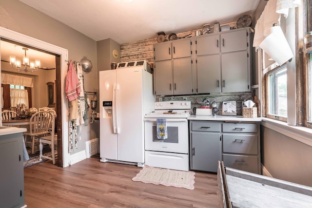 27960 County Highway 88, Carlisle Twp, MN 56537 - kitchen with white appliances, gray cabinets, a chandelier, decorative backsplash, and light wood finished floors