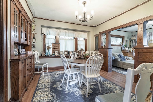 27960 County Highway 88, Carlisle Twp, MN 56537 - dining area featuring a chandelier, wood finished floors, crown molding, and ornate columns