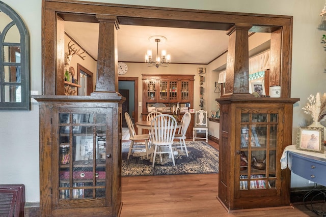 27960 County Highway 88, Carlisle Twp, MN 56537 - dining space with decorative columns, wood finished floors, a chandelier, and crown molding