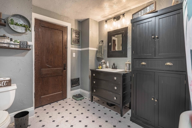 27960 County Highway 88, Carlisle Twp, MN 56537 - bathroom featuring tile patterned floors, vanity, a textured wall, and a textured ceiling