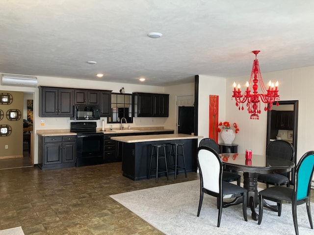 2040 Summit Dr, Cushing, MN 56443 - kitchen with black appliances, light countertops, a chandelier, a kitchen bar, and pendant lighting