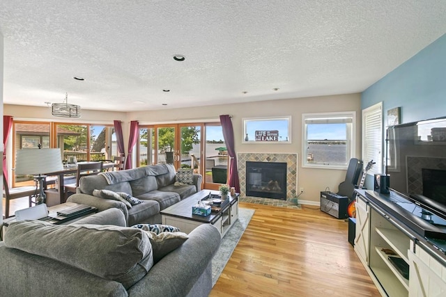 4936 210th St N, Forest Lake, MN 55025 - living area with a tiled fireplace, a textured ceiling, light wood-style flooring, and recessed lighting
