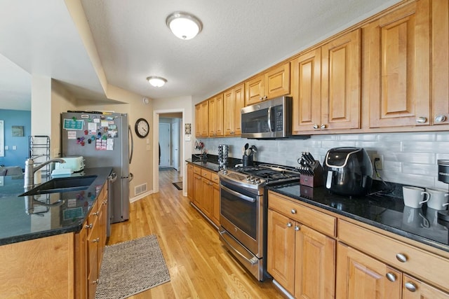 4936 210th St N, Forest Lake, MN 55025 - kitchen featuring stainless steel appliances, light wood-style flooring, backsplash, and dark stone counters