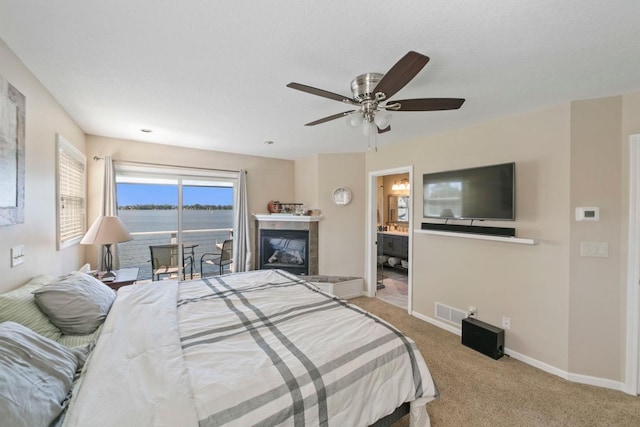 4936 210th St N, Forest Lake, MN 55025 - bedroom featuring carpet floors, access to exterior, a tiled fireplace, ceiling fan, and connected bathroom