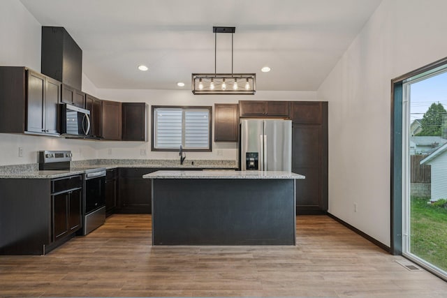 1002 Conway St, Saint Paul, MN 55106 - kitchen with appliances with stainless steel finishes, dark brown cabinets, a kitchen island, healthy amount of natural light, and recessed lighting