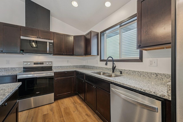 1002 Conway St, Saint Paul, MN 55106 - kitchen with stainless steel appliances, lofted ceiling, dark brown cabinetry, light wood-style flooring, and light stone countertops