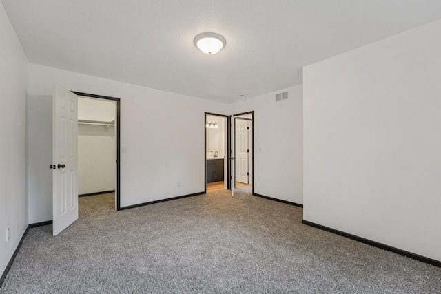 1002 Conway St, Saint Paul, MN 55106 - unfurnished bedroom with carpet, a spacious closet, and ensuite bath