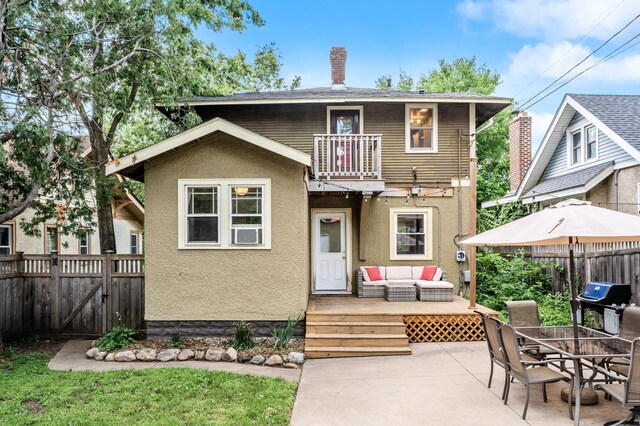 3841 Columbus Ave, Minneapolis, MN 55407 - rear view of property with a balcony, outdoor lounge area, a fenced backyard, and stucco siding
