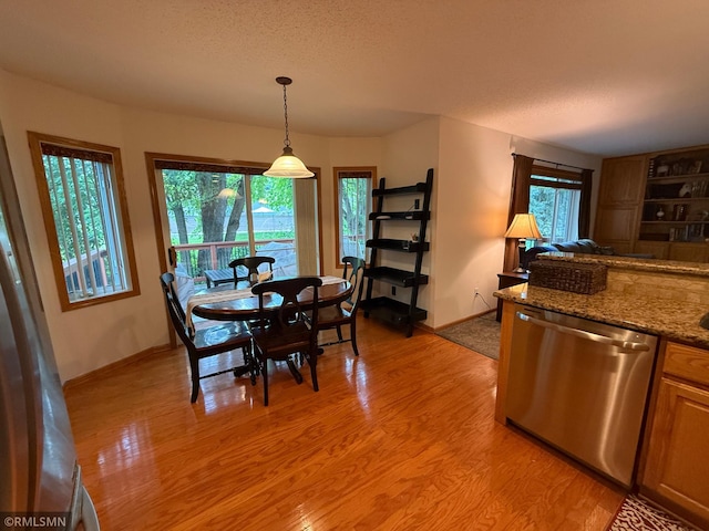 2052 Wilhelm Ct, Shakopee, MN 55379 - dining area with light wood-style flooring and a textured ceiling