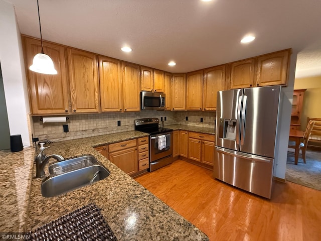 2052 Wilhelm Ct, Shakopee, MN 55379 - kitchen with stainless steel appliances, light wood-type flooring, tasteful backsplash, decorative light fixtures, and brown cabinets