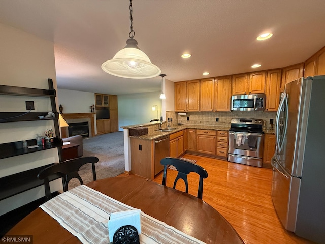 2052 Wilhelm Ct, Shakopee, MN 55379 - kitchen featuring appliances with stainless steel finishes, brown cabinetry, decorative light fixtures, and recessed lighting