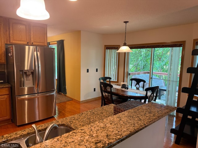 2052 Wilhelm Ct, Shakopee, MN 55379 - kitchen featuring stainless steel fridge, dark stone countertops, and light wood finished floors