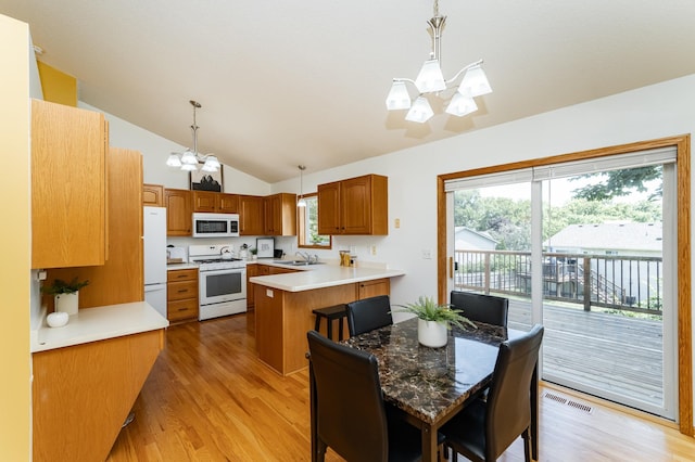 4626 Savannah Dr NW, Rochester, MN 55901 - kitchen with white appliances, a chandelier, light wood finished floors, vaulted ceiling, and a peninsula