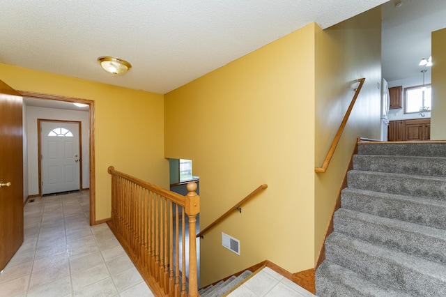 4626 Savannah Dr NW, Rochester, MN 55901 - stairway with tile patterned flooring and a textured ceiling
