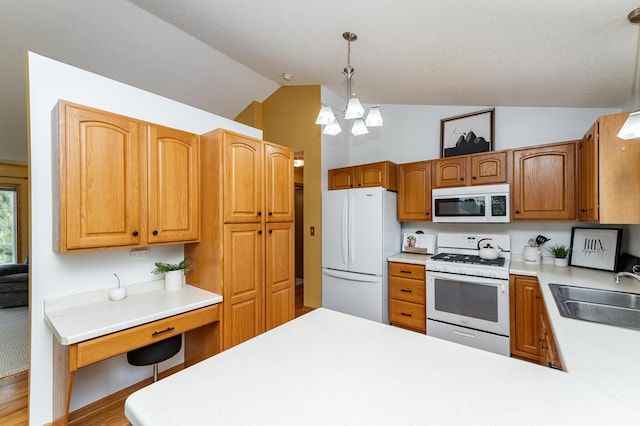 4626 Savannah Dr NW, Rochester, MN 55901 - kitchen with white appliances, vaulted ceiling, light countertops, decorative light fixtures, and a peninsula