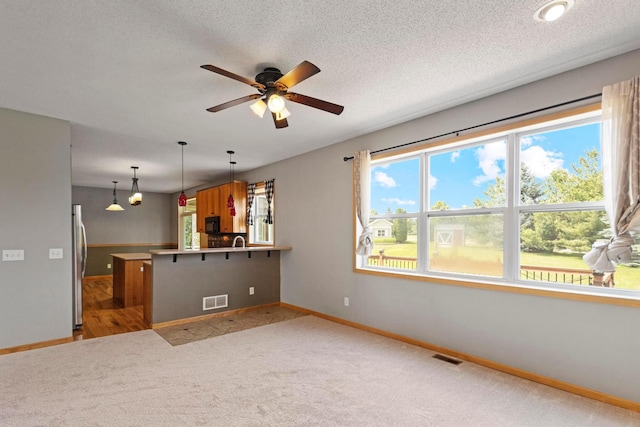14192 Bayberry Trl, Rosemount, MN 55068 - kitchen with freestanding refrigerator, a peninsula, a ceiling fan, and light colored carpet