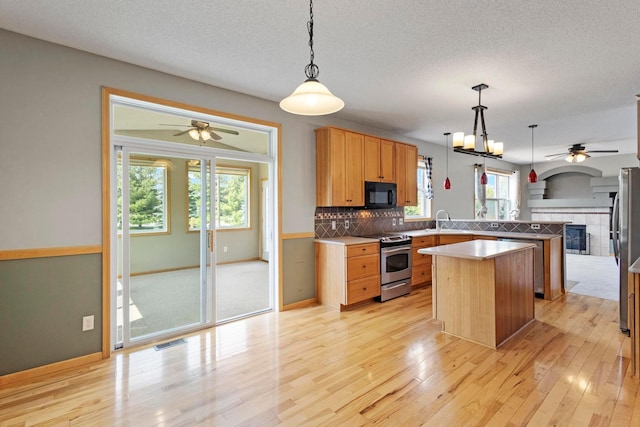 14192 Bayberry Trl, Rosemount, MN 55068 - kitchen featuring stainless steel appliances, a ceiling fan, open floor plan, a peninsula, and light wood-type flooring