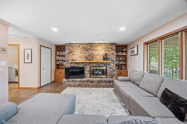 2636 18th St S Unit 8, Fargo, ND 58103 - living area featuring wood finished floors, a fireplace, washer / dryer, recessed lighting, and an AC wall unit