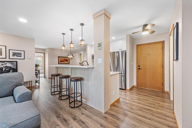 2636 18th St S Unit 8, Fargo, ND 58103 - kitchen featuring freestanding refrigerator, a kitchen breakfast bar, light wood-style flooring, open floor plan, and white cabinets