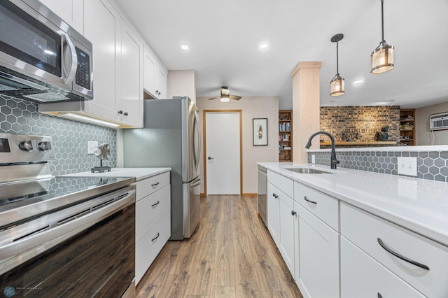 2636 18th St S Unit 8, Fargo, ND 58103 - kitchen featuring stainless steel appliances, decorative backsplash, light countertops, wood finished floors, and white cabinets