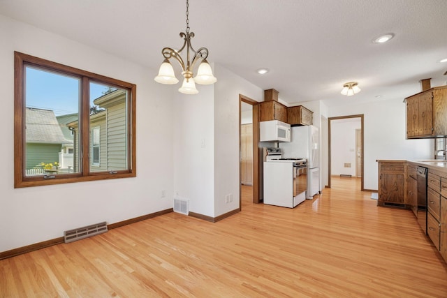 8300 Sheridan Ave S, Bloomington, MN 55431 - kitchen with white appliances, light wood finished floors, a chandelier, recessed lighting, and pendant lighting