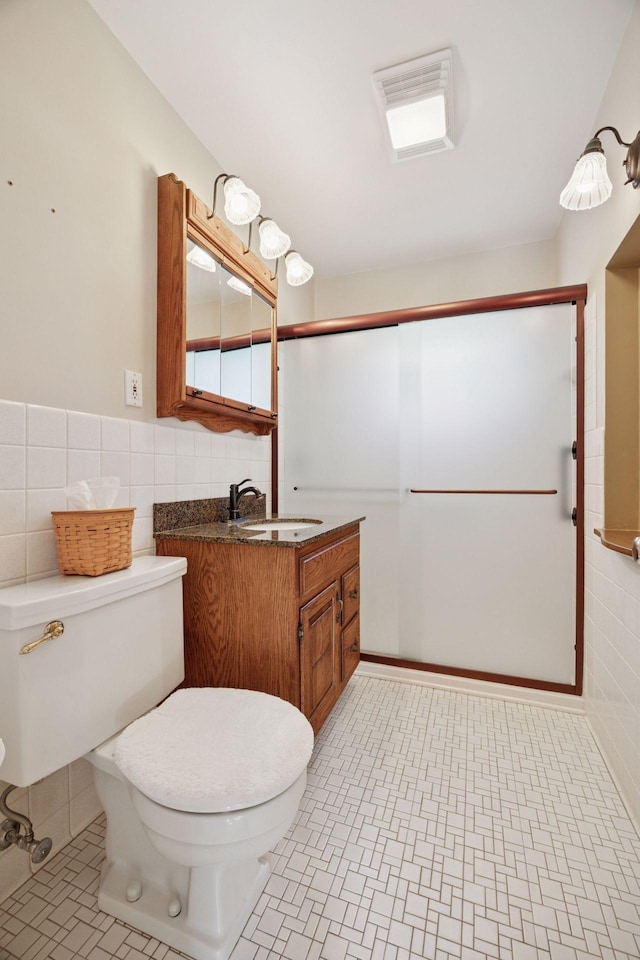 8300 Sheridan Ave S, Bloomington, MN 55431 - bathroom with tile walls, vanity, a shower with door, and wainscoting