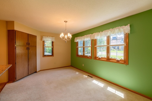 10 Cree Point Dr, Mankato, MN 56001 - unfurnished dining area featuring light carpet, a chandelier, and a textured ceiling
