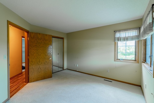 10 Cree Point Dr, Mankato, MN 56001 - unfurnished bedroom featuring carpet, a closet, and a textured ceiling