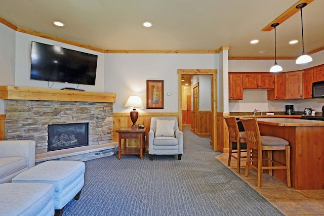 24909 Sandy Ln, Bay Lake Twp, MN 56444 - carpeted living room featuring wainscoting, recessed lighting, a stone fireplace, and wood walls