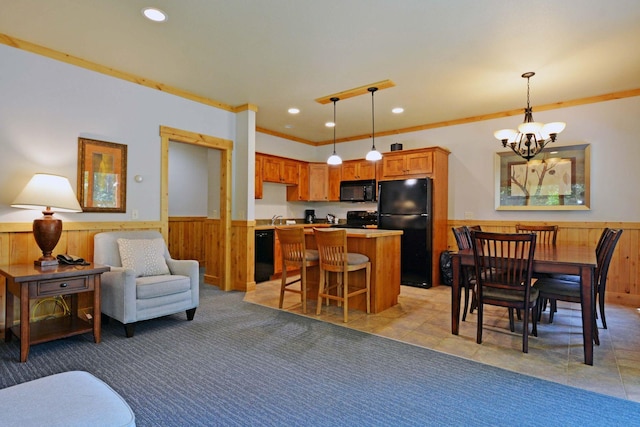 24909 Sandy Ln, Bay Lake Twp, MN 56444 - kitchen with wainscoting, a chandelier, black appliances, a center island, and wooden walls