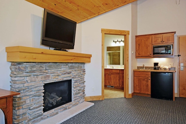 24909 Sandy Ln, Bay Lake Twp, MN 56444 - kitchen with lofted ceiling, black microwave, a fireplace, carpet, and fridge
