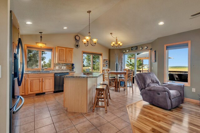 511 8th St SW, Rice, MN 56367 - kitchen featuring dishwasher, light brown cabinets, a chandelier, a center island, and lofted ceiling
