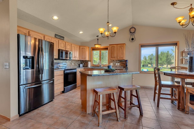 511 8th St SW, Rice, MN 56367 - kitchen with appliances with stainless steel finishes, a chandelier, light brown cabinetry, vaulted ceiling, and decorative backsplash