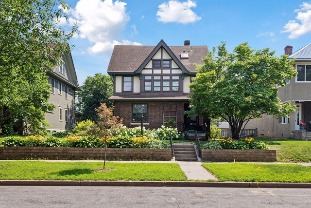 1088 Lincoln Ave, Saint Paul, MN 55105 - english style home with a front lawn, brick siding, a shingled roof, and stucco siding