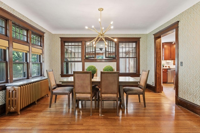 1088 Lincoln Ave, Saint Paul, MN 55105 - dining room featuring wallpapered walls, radiator heating unit, a chandelier, and wood finished floors