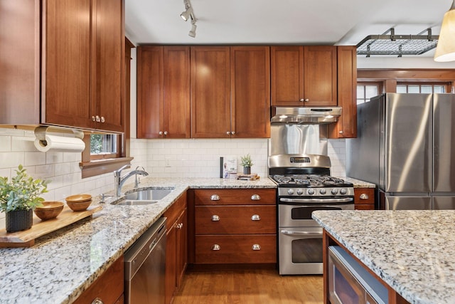 1088 Lincoln Ave, Saint Paul, MN 55105 - kitchen featuring stainless steel appliances, under cabinet range hood, wood finished floors, and light stone countertops