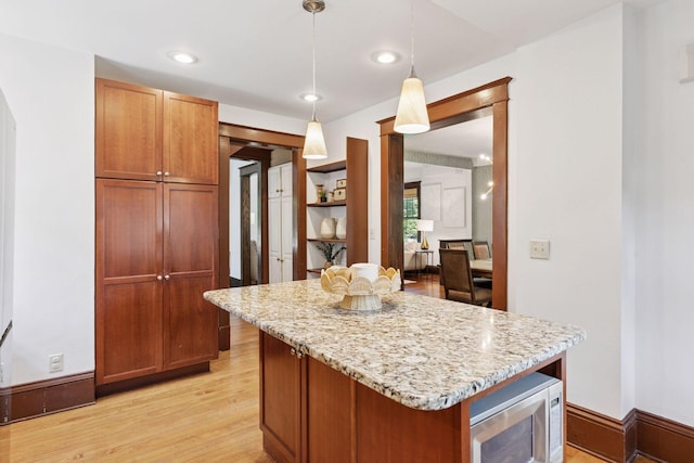 1088 Lincoln Ave, Saint Paul, MN 55105 - kitchen with light wood-style floors, light stone countertops, a center island, decorative light fixtures, and recessed lighting