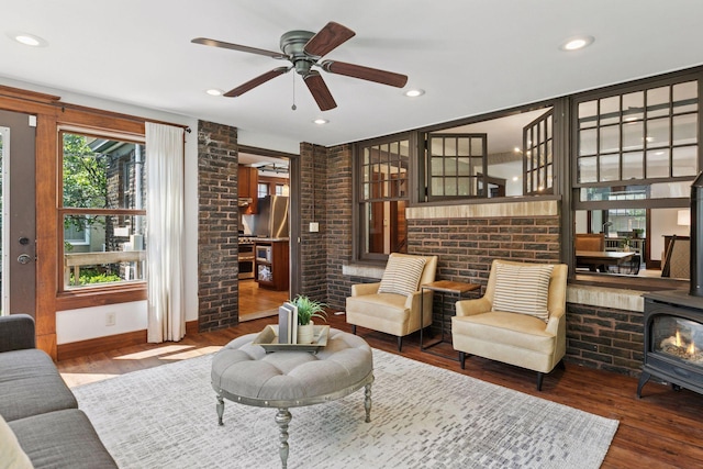 1088 Lincoln Ave, Saint Paul, MN 55105 - living room with a wood stove, wood finished floors, a ceiling fan, brick wall, and recessed lighting