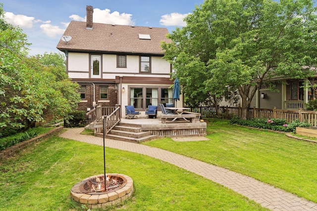 1088 Lincoln Ave, Saint Paul, MN 55105 - back of property featuring stucco siding, a chimney, a wooden deck, a fire pit, and roof with shingles