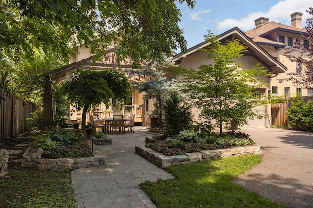 582 Summit Ave, Saint Paul, MN 55102 - view of front facade featuring stucco siding, a patio, driveway, and a chimney