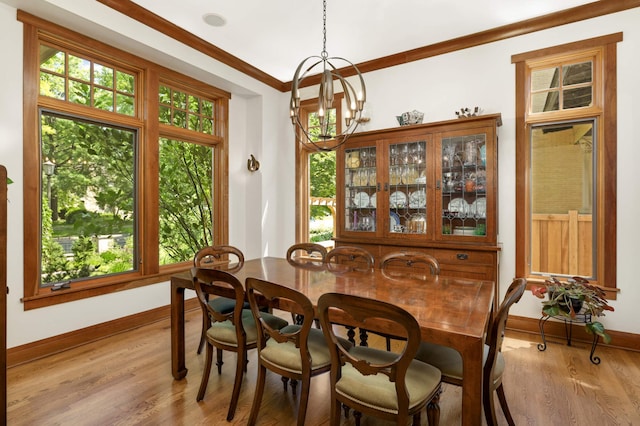 582 Summit Ave, Saint Paul, MN 55102 - dining area with healthy amount of natural light, light wood-style flooring, ornamental molding, and a chandelier
