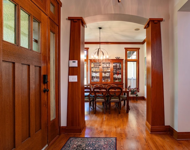 582 Summit Ave, Saint Paul, MN 55102 - foyer with light wood-style flooring, arched walkways, a chandelier, and ornamental molding