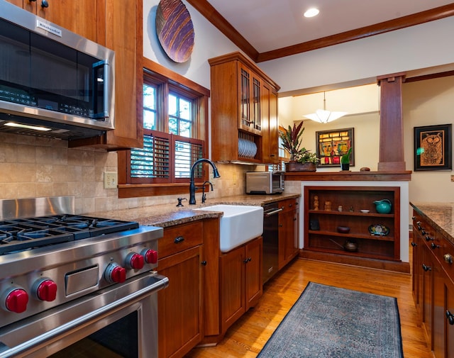 582 Summit Ave, Saint Paul, MN 55102 - kitchen with appliances with stainless steel finishes, light stone countertops, brown cabinets, light wood-style floors, and recessed lighting