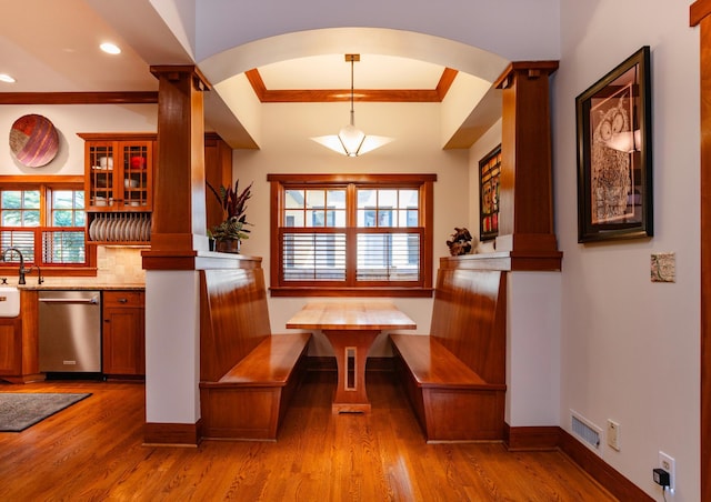 582 Summit Ave, Saint Paul, MN 55102 - unfurnished dining area featuring ornate columns, ornamental molding, light wood-type flooring, arched walkways, and recessed lighting