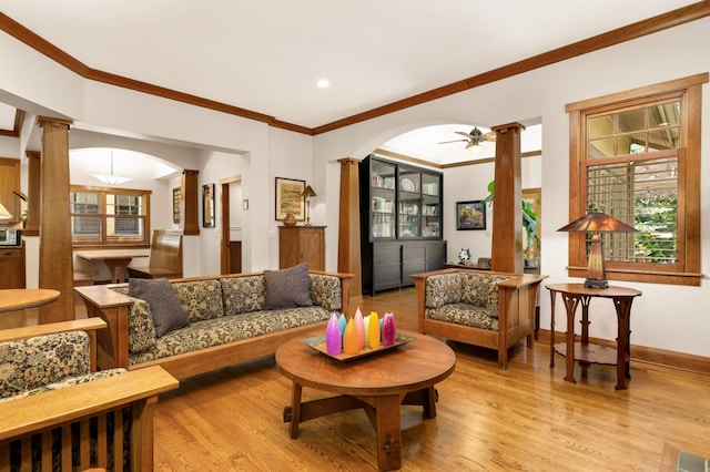 582 Summit Ave, Saint Paul, MN 55102 - living room with decorative columns, crown molding, light wood-style flooring, ceiling fan, and arched walkways